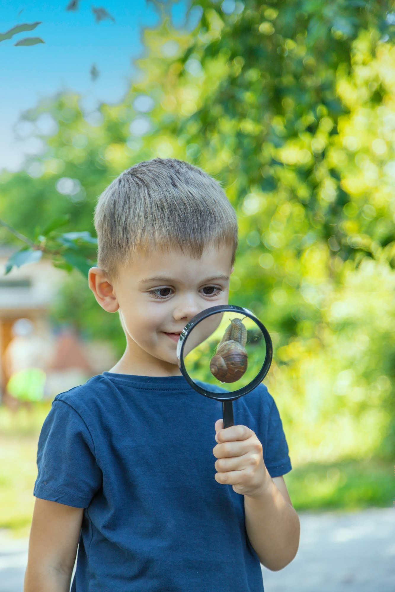 The child looks at the snail nature. Selective focus.